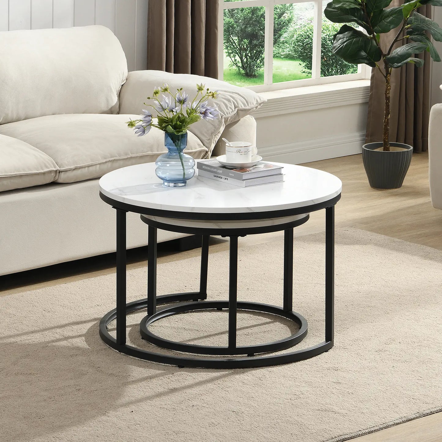 Modern round nesting coffee tables with white marble-look tops and black metal frames, offering flexible layered or separate use for small living spaces.