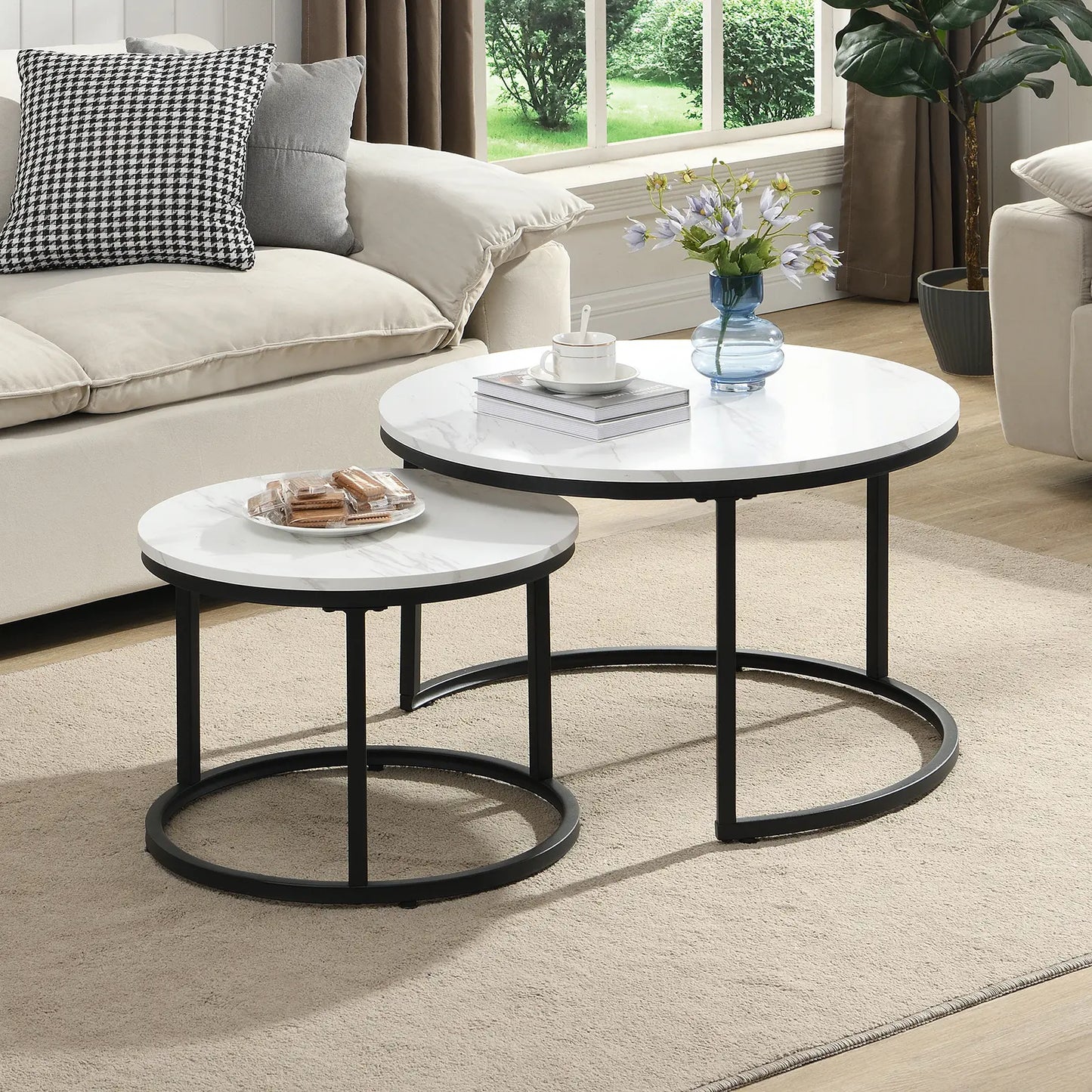 Modern round nesting coffee tables with white marble-look tops and black metal frames, offering flexible layered or separate use for small living spaces.