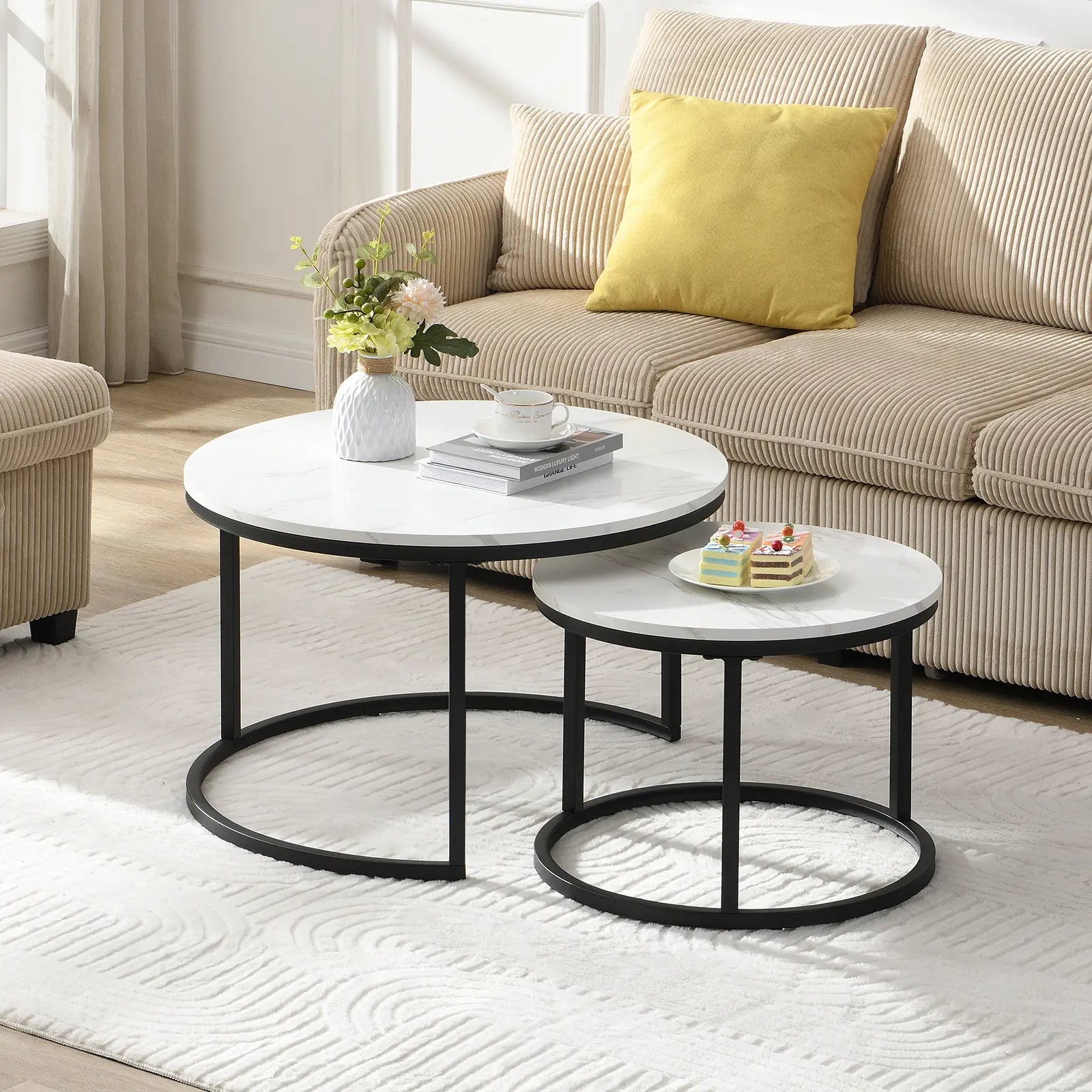 Modern round nesting coffee tables with white marble-look tops and black metal frames, offering flexible layered or separate use for small living spaces.